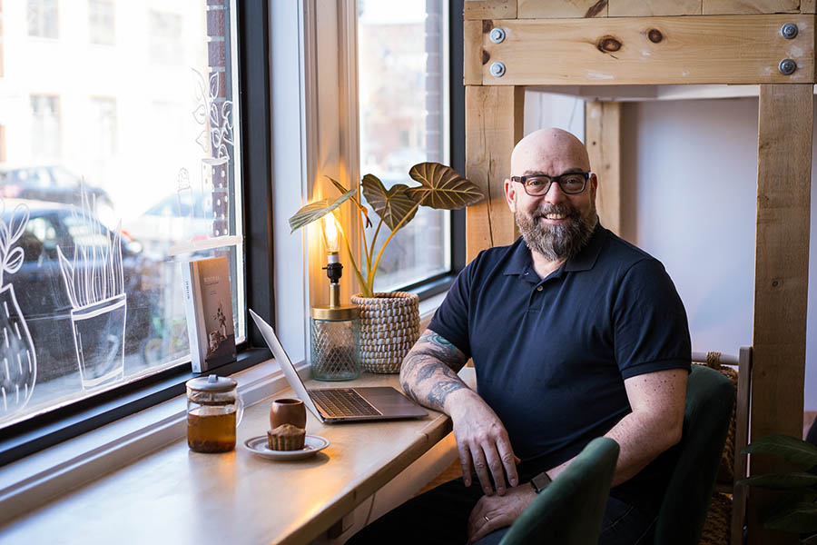 photographe de portraits corporatifs lifestyle à Montréal - photo d'un client assis au comptoir d'un café regardant vers l'objectif